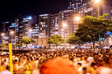 NITEROI, RIO DE JANEIRO, BRAZIL - 2019 için 2018: Yeni yılın (Reveillon) gelişinin fotoğrafları. Partilerde, gösterilerde ve havai fişeklerde. İnsanlar plajdaki havai fişek patlamalarının ışık ve renklerini görmek için akın ediyorlar..