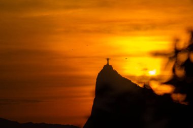 Rio de Janeiro, Brezilya: 2021 - Cristo Redentor Panoraması (Cristo Redentor) turuncu gökyüzü ile gün batımında