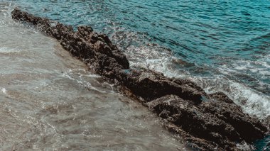 Gün boyunca plajda kaya oluşumlarının (taşlar) dokusu ve keskinliğiyle görüntüsü