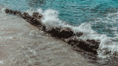 Gün boyunca plajda kaya oluşumlarının (taşlar) dokusu ve keskinliğiyle görüntüsü