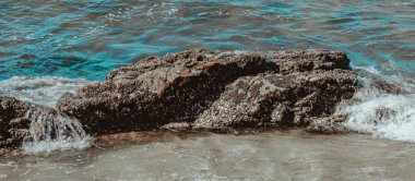 Gün boyunca plajda kaya oluşumlarının (taşlar) dokusu ve keskinliğiyle görüntüsü