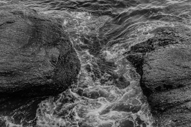 Gün boyunca plajda kaya oluşumlarının (taşlar) dokusu ve keskinliğiyle görüntüsü