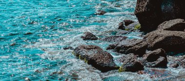 Gün boyunca plajda kaya oluşumlarının (taşlar) dokusu ve keskinliğiyle görüntüsü