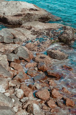 Gün boyunca plajda kaya oluşumlarının (taşlar) dokusu ve keskinliğiyle görüntüsü