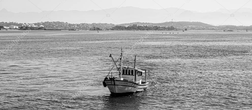 Fishing boat surrounded by seabirds in Guanabara Bay, Rio de Janeiro, Brazil. Artisanal fishing is practiced autonomously, by traditional fishermen, or in a family economy regime. 