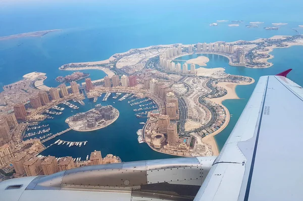 Katar 'ın başkenti Doha üzerinde uçan Basra Körfezi. Hava görüntüsü, uçağın üst görüntüsü. Uçak kanadı görünüyor. Modern zengin ortadoğu şehri. Seyahat, tatil