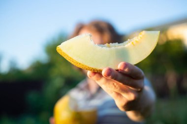 Erkek (erkek) ellerindeki kavun dilimleri insanın önünde. Kavun ellerinde ve yaz ışığı var. Bahçede yetişen kavun