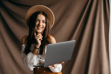 Sevimli genç, inanılmaz indirimli modern teknoloji aleti uygulamaları blogcusu kahverengi arka planı izole etti.