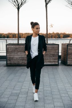 Şehir arka planında takım elbise giyen güzel Afrikalı iş kadınının tam boy portresi.. 