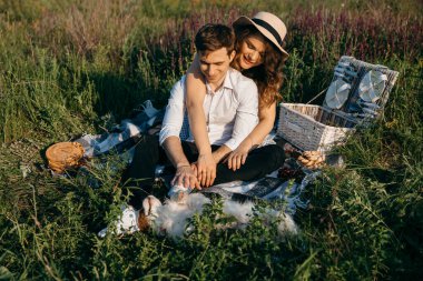 Sevgi dolu bir çift, sevgili köpekleriyle birlikte doğada piknik yapar.