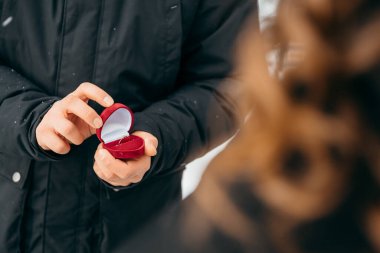 Adam elinde evlilik teklifi için yüzüklü bir kutu tutuyor.