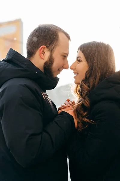 Um homem aquece suavemente as mãos de sua amada garota no tempo frio — Fotografia de Stock