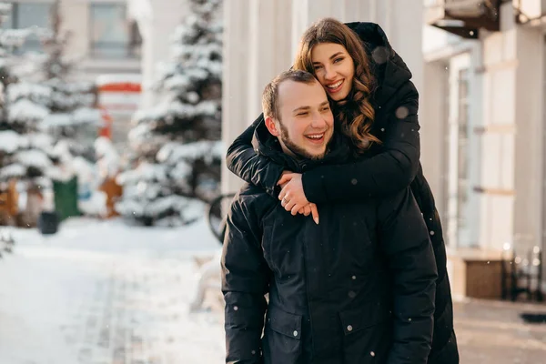 Una pareja amorosa en un suave abrazo en el fondo de una ciudad nevada — Foto de Stock