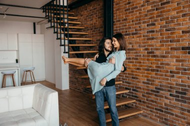 Koca, sevgili karısını kollarına alır.