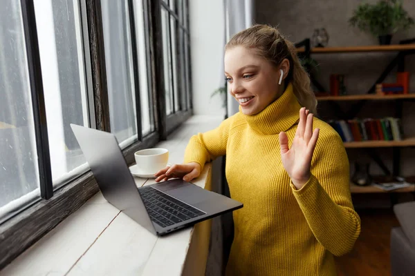 Mladá žena má videohovor na notebooku doma — Stock fotografie