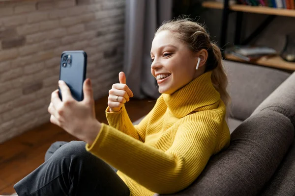 Genç bir kadın arkadaşlarıyla görüntülü konuşma yapmak için telefon kullanıyor. — Stok fotoğraf