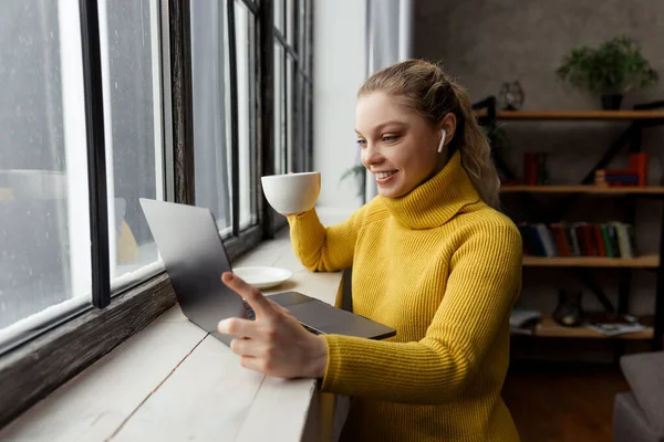 Mladá žena má videohovor na notebooku doma — Stock fotografie