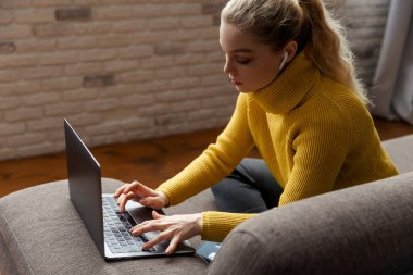 Genç bir kadın evdeki dizüstü bilgisayarında video görüşmesi yapıyor.