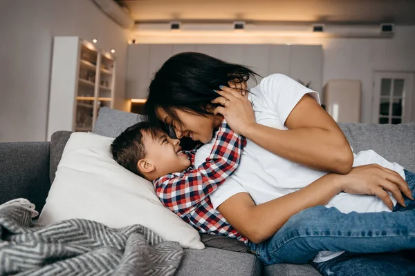Young afro american mom hugs her beloved son tenderly — Stock Photo, Image