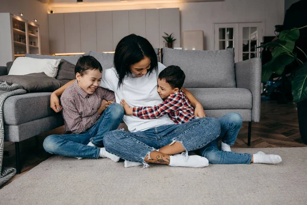 Young afro american mom hugs her beloved little children tenderly — Stock Photo, Image