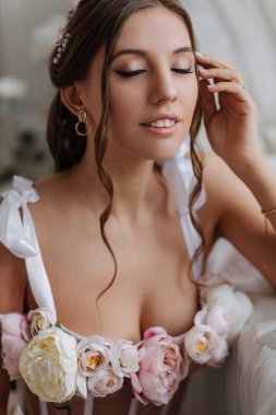  Çiçekli, pembe gelinlikli güzel bir gelinin narin portresi.