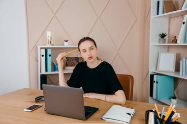 İş kadını masada oturur, dizüstü bilgisayara bakar, not alır, internetteki webinar 'ın kişisel gelişmesine katılır.