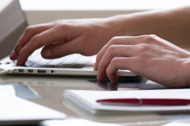 Dizüstü bilgisayarda yazan genç adam.