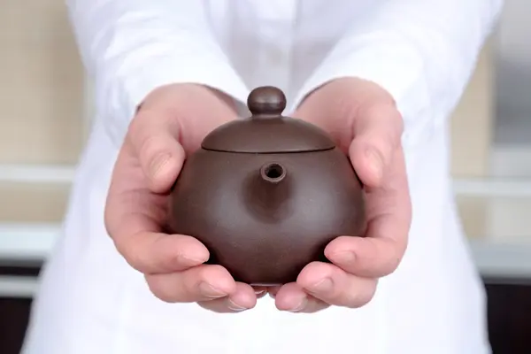 Teapot in her hands — Stock Photo, Image