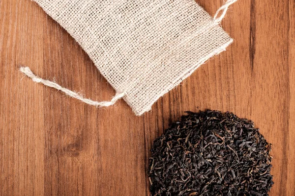 Arpillera vintage con té sobre fondo de madera — Foto de Stock