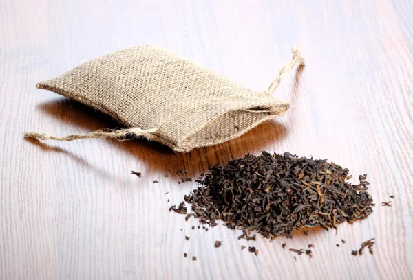 Arpillera vintage con té sobre fondo de madera — Foto de Stock