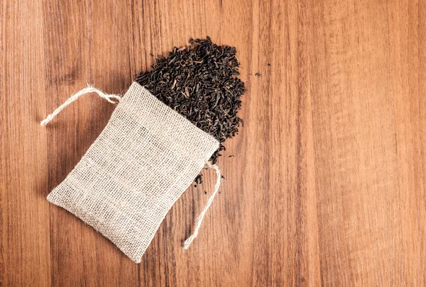 Arpillera vintage con té sobre fondo de madera — Foto de Stock