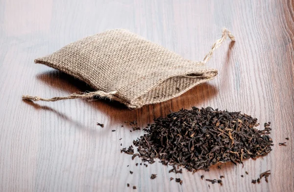 Vintage burlap with tea on wooden background — Stock Photo, Image