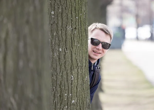 Jonge man achter de boom — Stockfoto