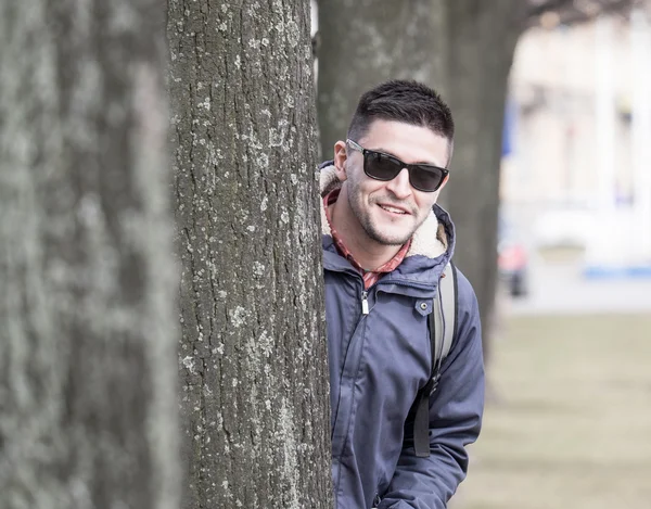 Jonge man achter de boom — Stockfoto