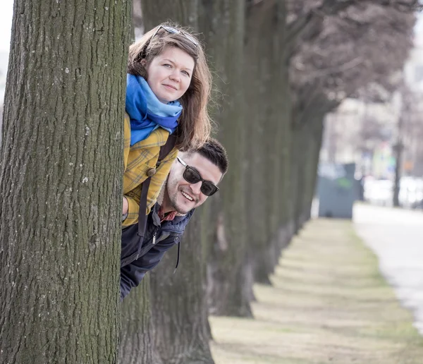 Jovem casal atrás da árvore — Fotografia de Stock