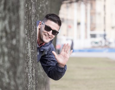 Ağacın arkasında genç adam