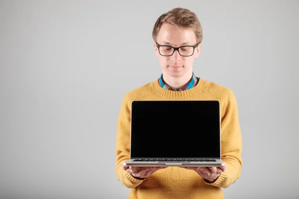 Чоловік представляє щось на порожньому екрані ноутбука — стокове фото