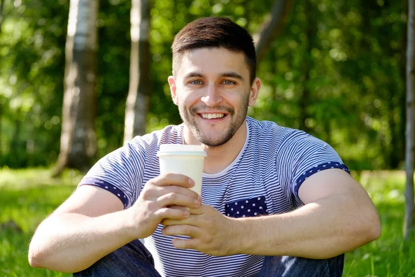 Человек с кофе в парке — стоковое фото
