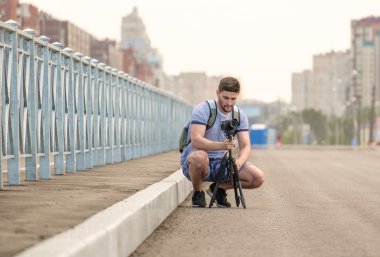 Tripod üzerinde kamera ile adam