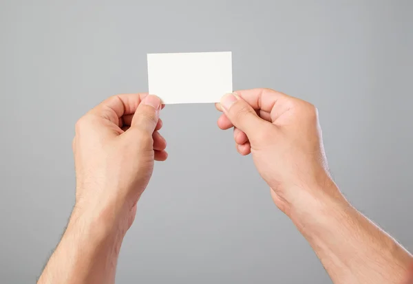 Mano del hombre sosteniendo la tarjeta de visita en blanco — Foto de Stock