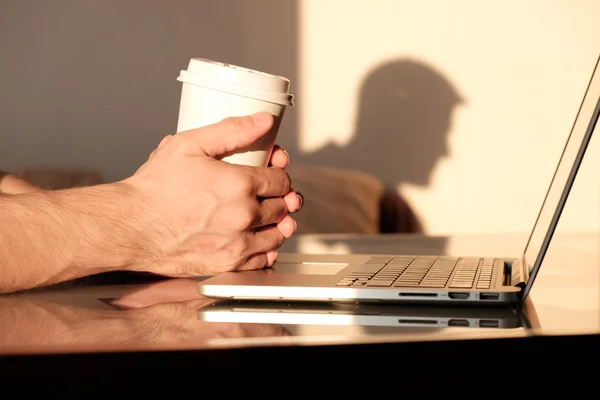 Mãos do homem segurando copo de café em branco — Fotografia de Stock