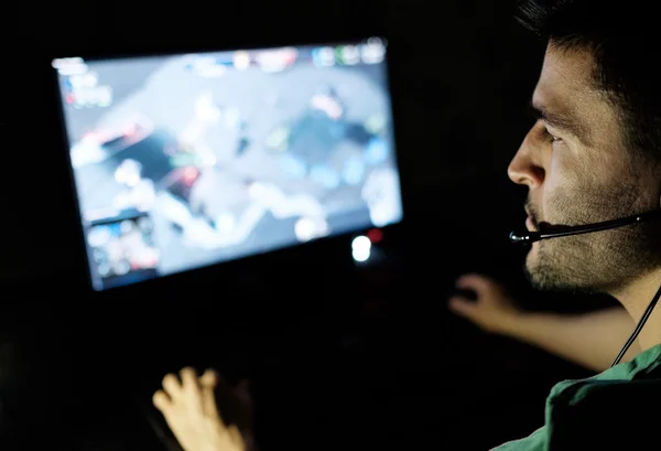 stock image Man playing video game in dark room