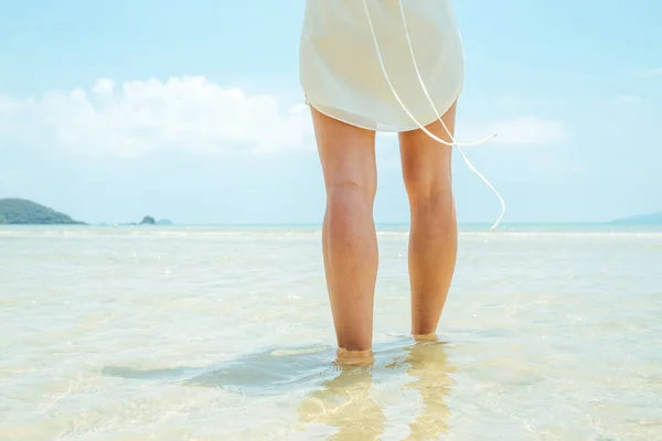 Low angle woman walking barefoot on beach