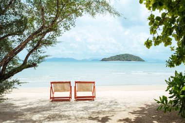 Güzel kumlu bir sahilde iki güneşli yatak