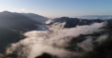 Kyoto çevresindeki Japon dağlarında güneşli bir günde dağların arasında sıkışmış puslu bulutlar.