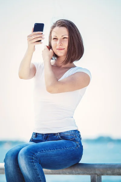 Girl woman looking at cell phone making selfie — Stock Photo, Image