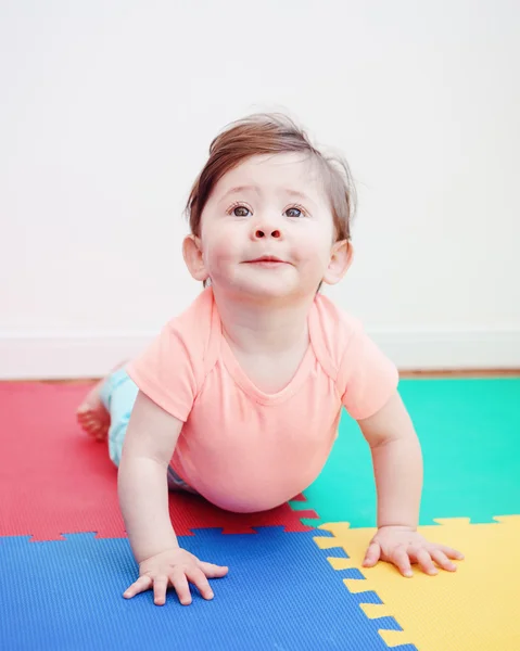 Portrait of cute adorable Caucasian smile baby boy girl lying on floor in kids room looking in camera, natural window light, lifestyle — Stok Foto