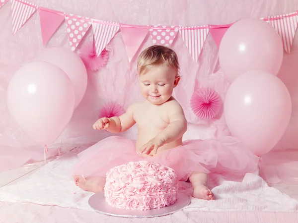 Portrait de mignonne adorable petite fille caucasienne aux yeux bleus en jupe tutu rose célébrant son premier anniversaire avec gâteau gastronomique et ballons détournant les yeux, gâteau smash concept première année — Photo