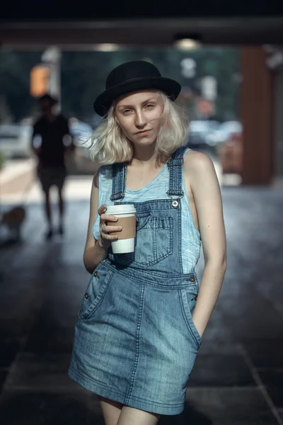 Retrato de belo branco adolescente loira modelo alternativo menina mulher em camisa azul, jeans romper olhando na câmera segurando xícara de café, tonificado com filtros Instagram — Fotografia de Stock