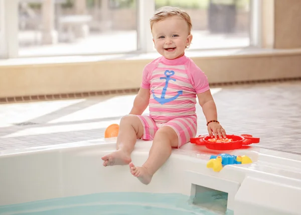 Portrait of white Caucasian baby girl laughing sitting on swimming-pool nosing looking in camera, training to swim, healthy active lifestyle — Stock Photo, Image